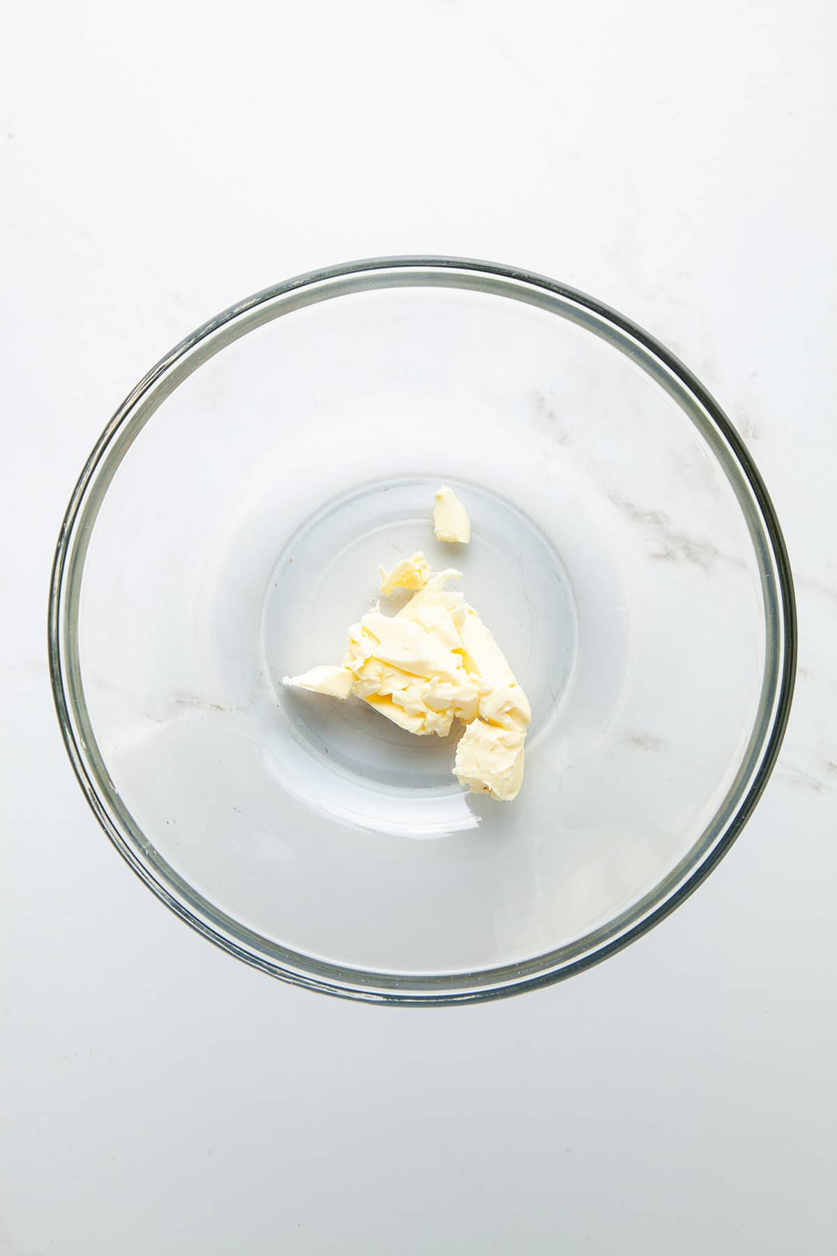 A glass bowl with a large chunk of butter.