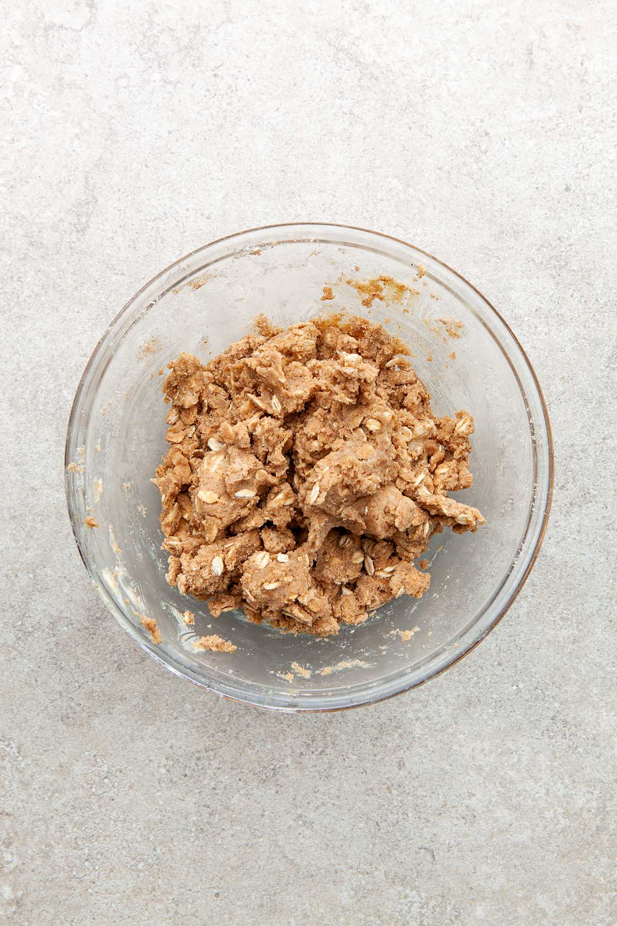 A bowl of butter mixed with flour, brown sugar, and oats.