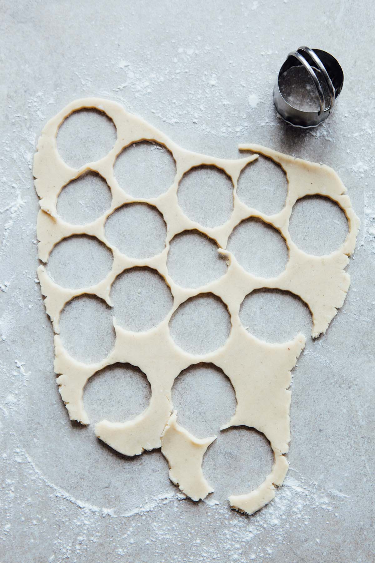 Rolled cookie dough with cut outs removed.