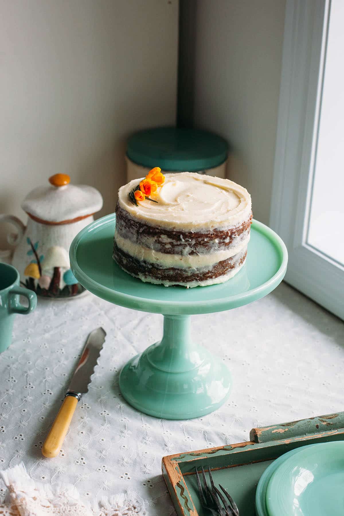 Spiced carrot cake with pineapple on a green milk glass stand.