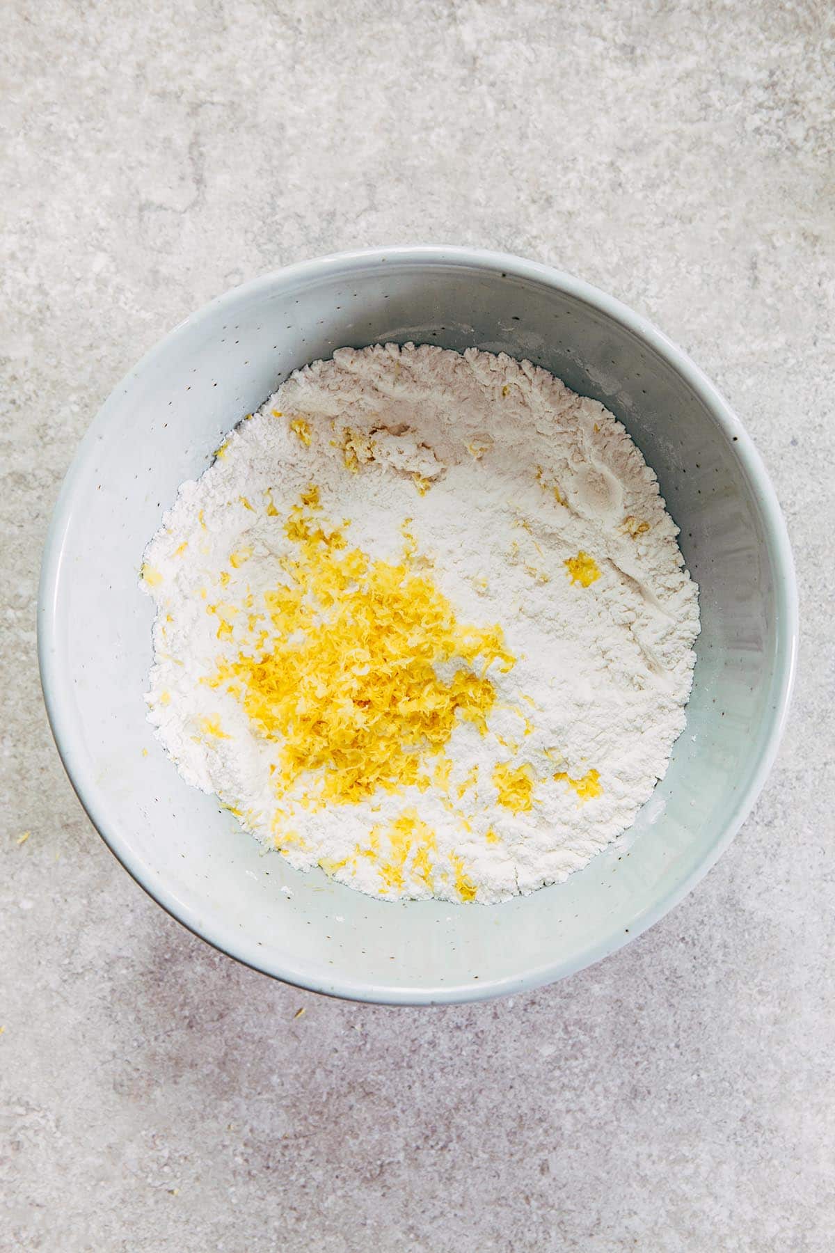 A bowl of flour and grated lemon zest.