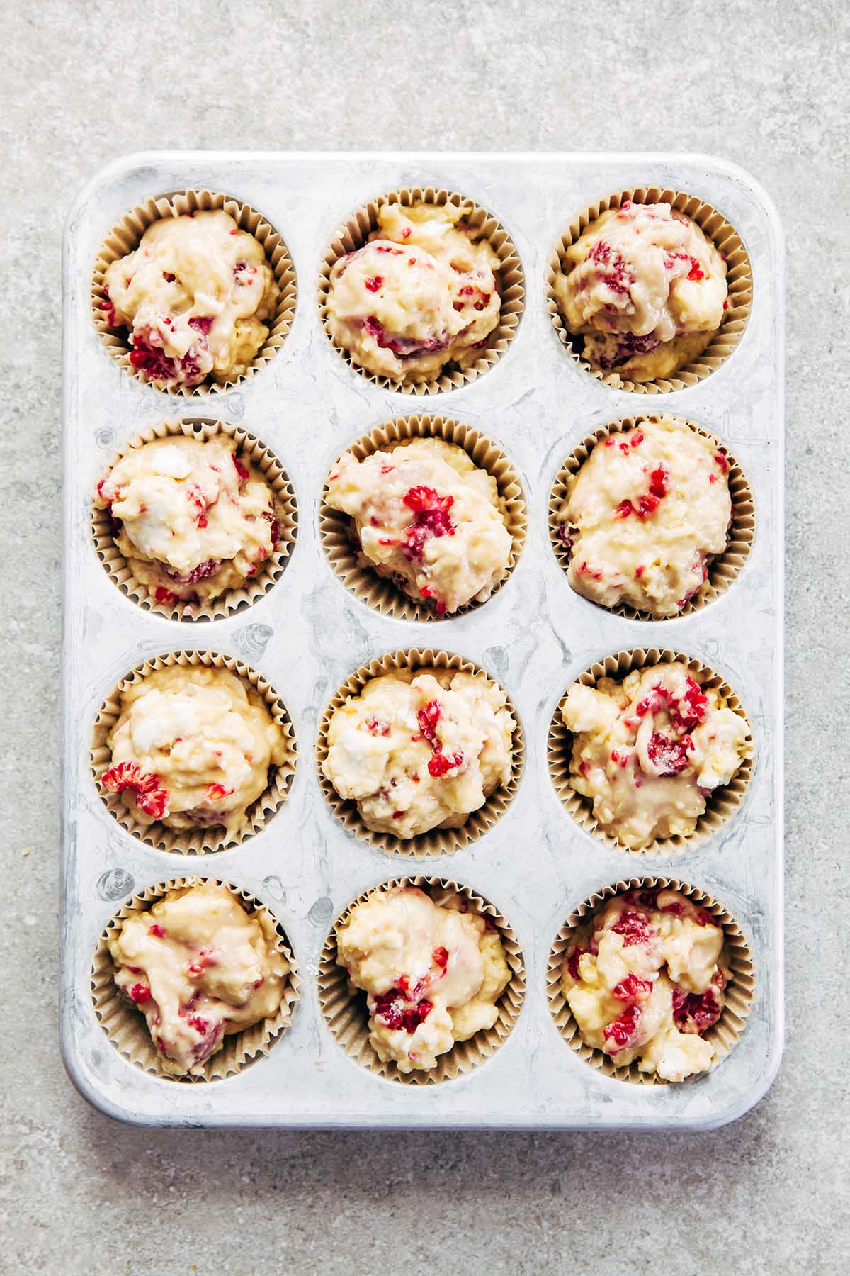 12 unbaked muffins in a tin.