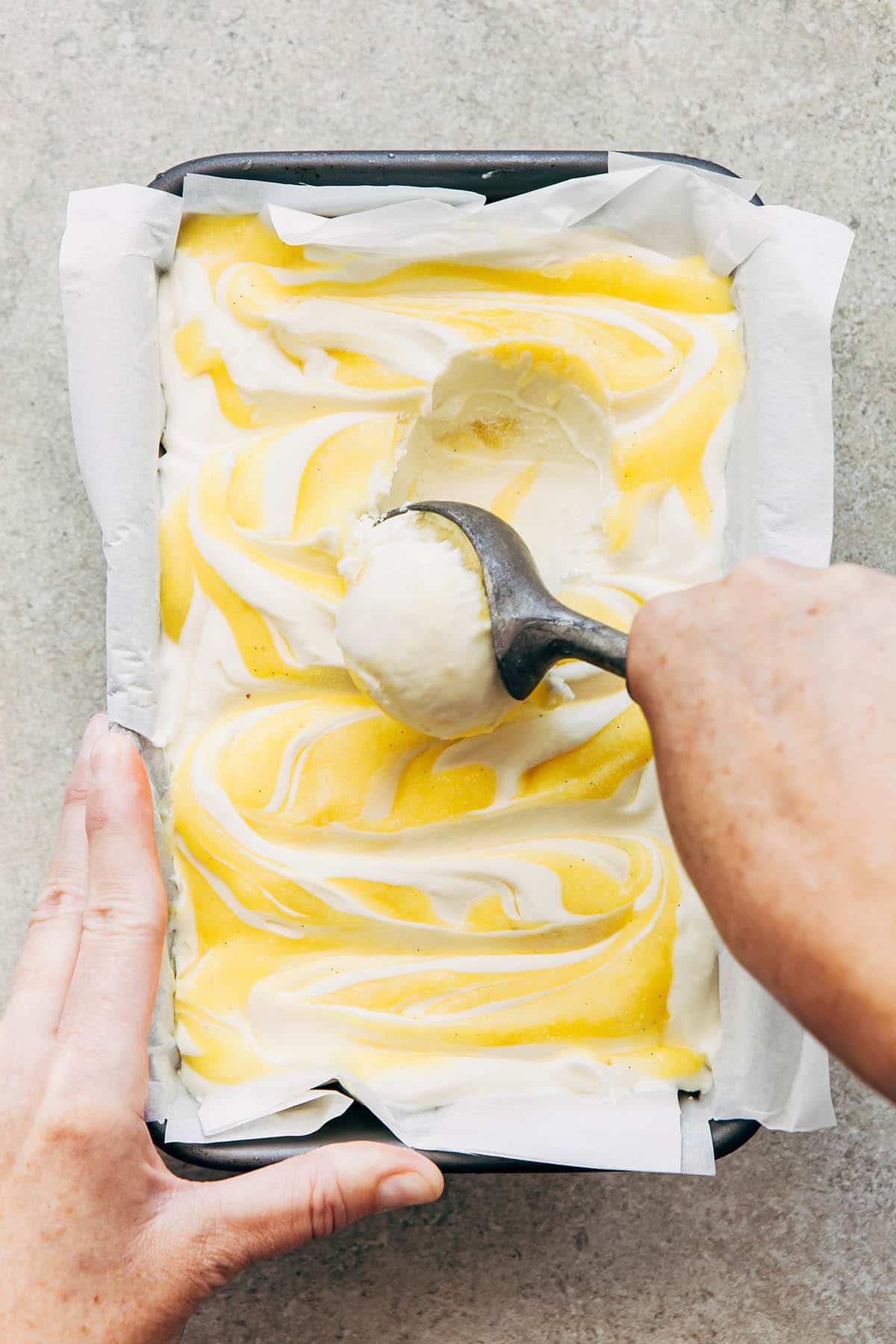 A hand scooping ice cream.