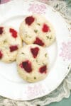Close up of three raspberry thyme scones on a plate.
