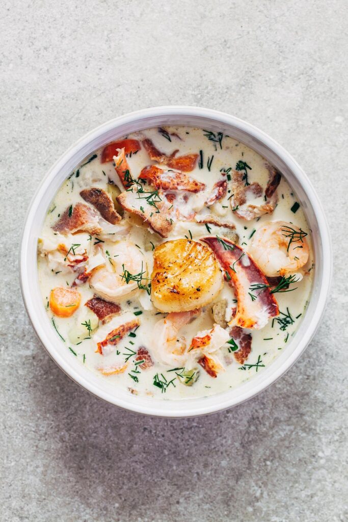 A bowl of Nova Scotia seafood chowder topped with a pan seared scallop.