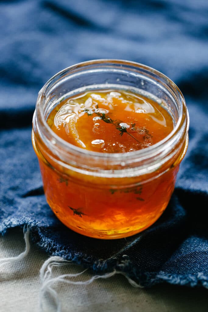 A jar of small batch peach jam with maple and whisky.