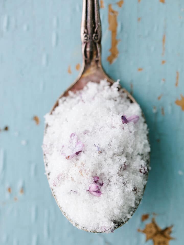 Sugar and lilac blossoms on a spoon.
