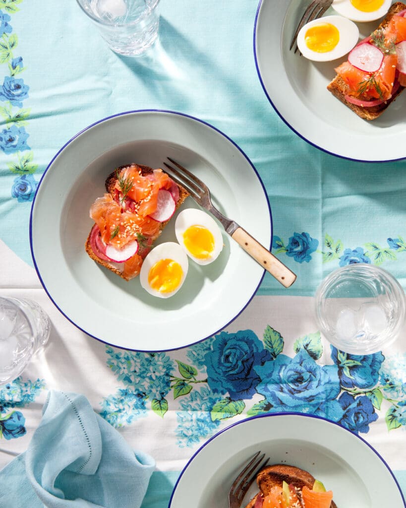 A bowl with salmon gravlax toast topped with a runny boiled egg.