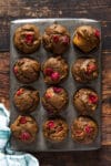 Overhead of mini pumpkin cranberry muffins in a baking tin.