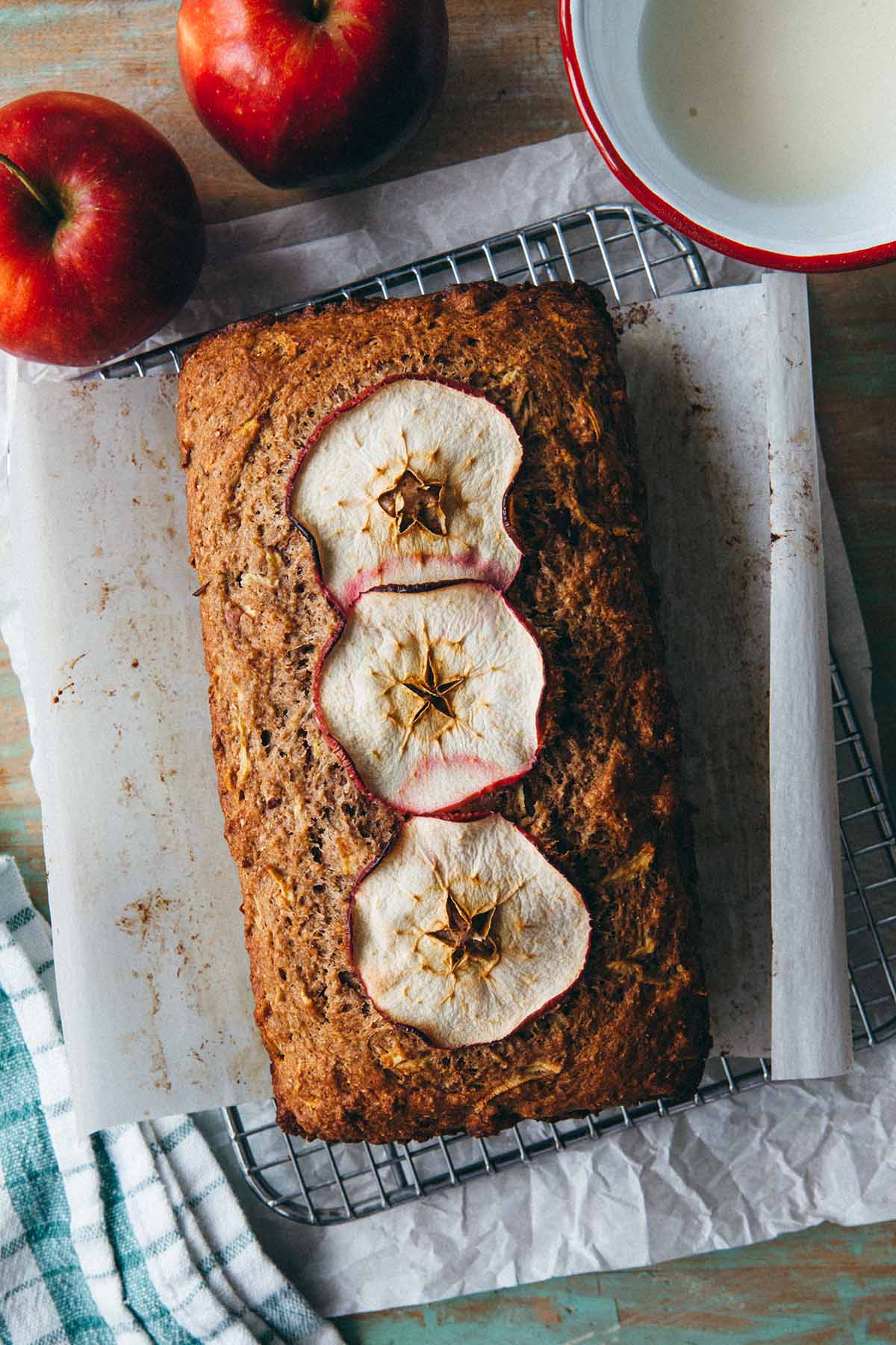 A fully baked apple loaf cake cooking on a wire rack.