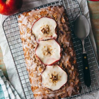 An apple loaf cake on a wire rack topped with apple cider glaze.