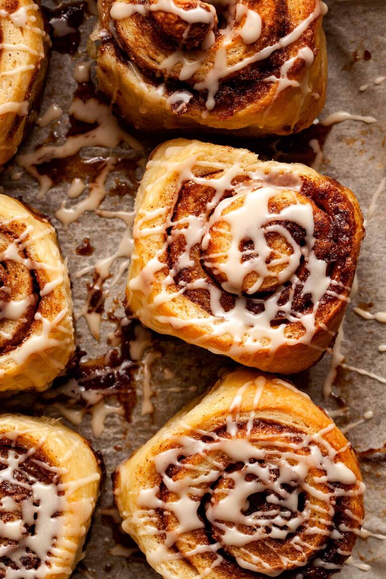 Close up overhead image of a small batch cinnamon roll surrounded by other rolls from the batch.