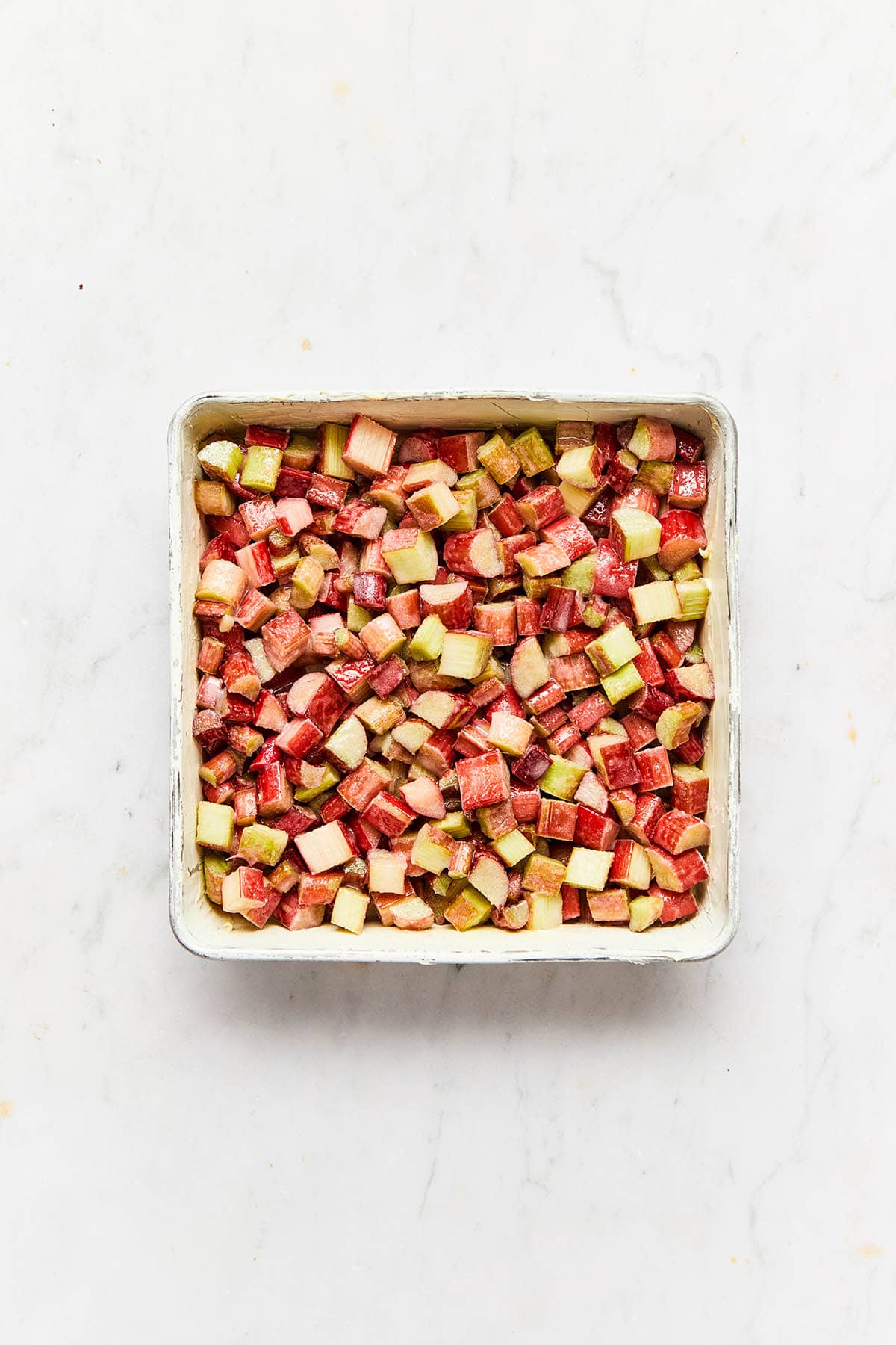 Chopped rhubarb in a square baking in.