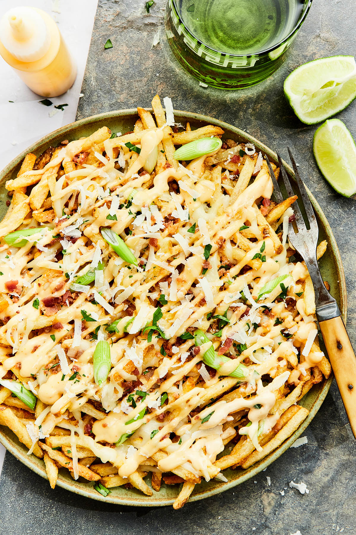 A plate of loaded fries drizzled generously with spicy garlic aioli.