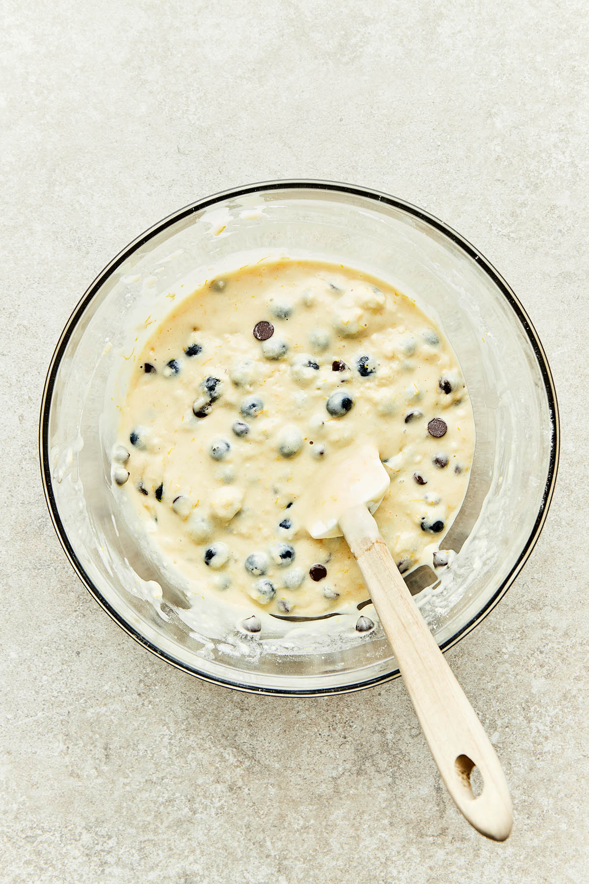 A bowl of batter with blueberries and chocolate chips.