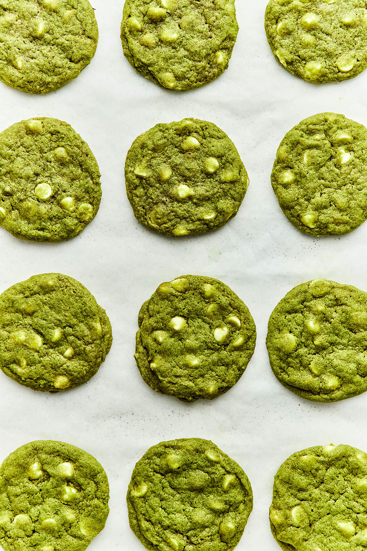 Close up of matcha chocolate chip cookies on a baking sheet.