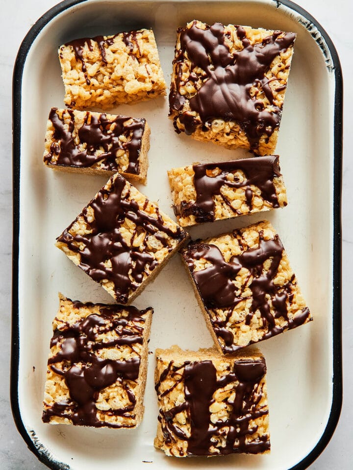 A white enamel pan with black trim filled with peanut butter Rice Krispie treats.