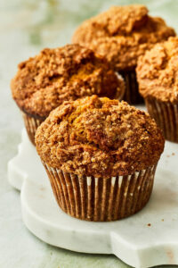 Pumpkin banana muffins on a marble serving board.