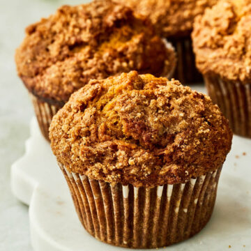 Pumpkin banana muffins on a marble serving board.