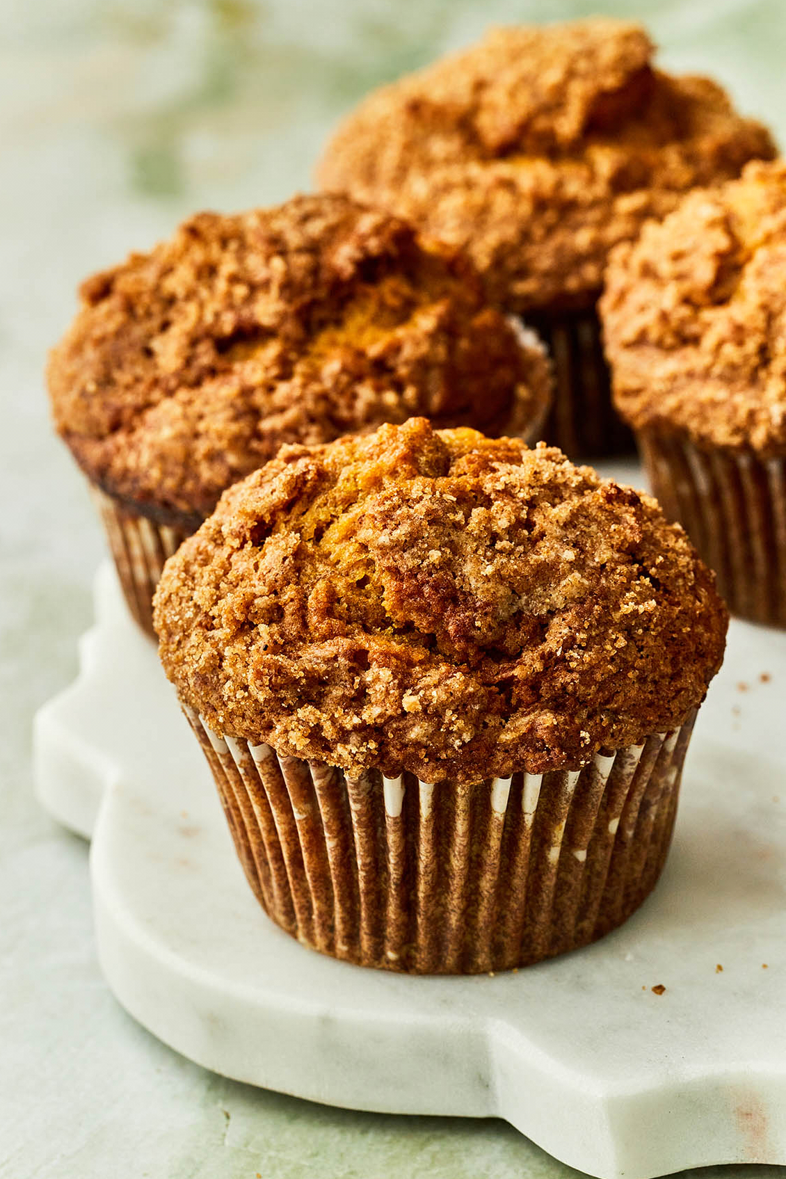 Pumpkin banana muffins on a marble serving board.