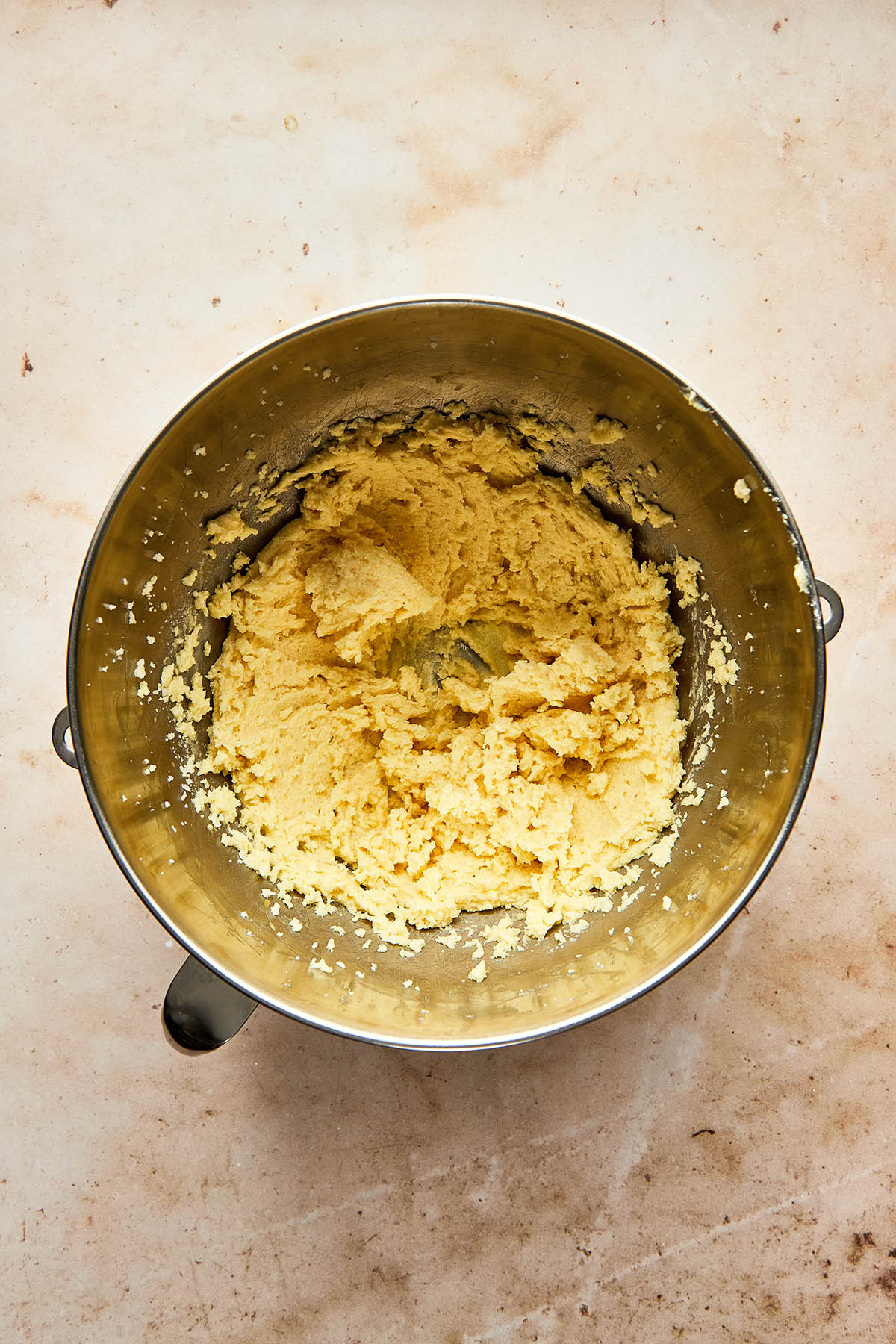 Mixed wet cookie dough ingredients in a metal mixing bowl.