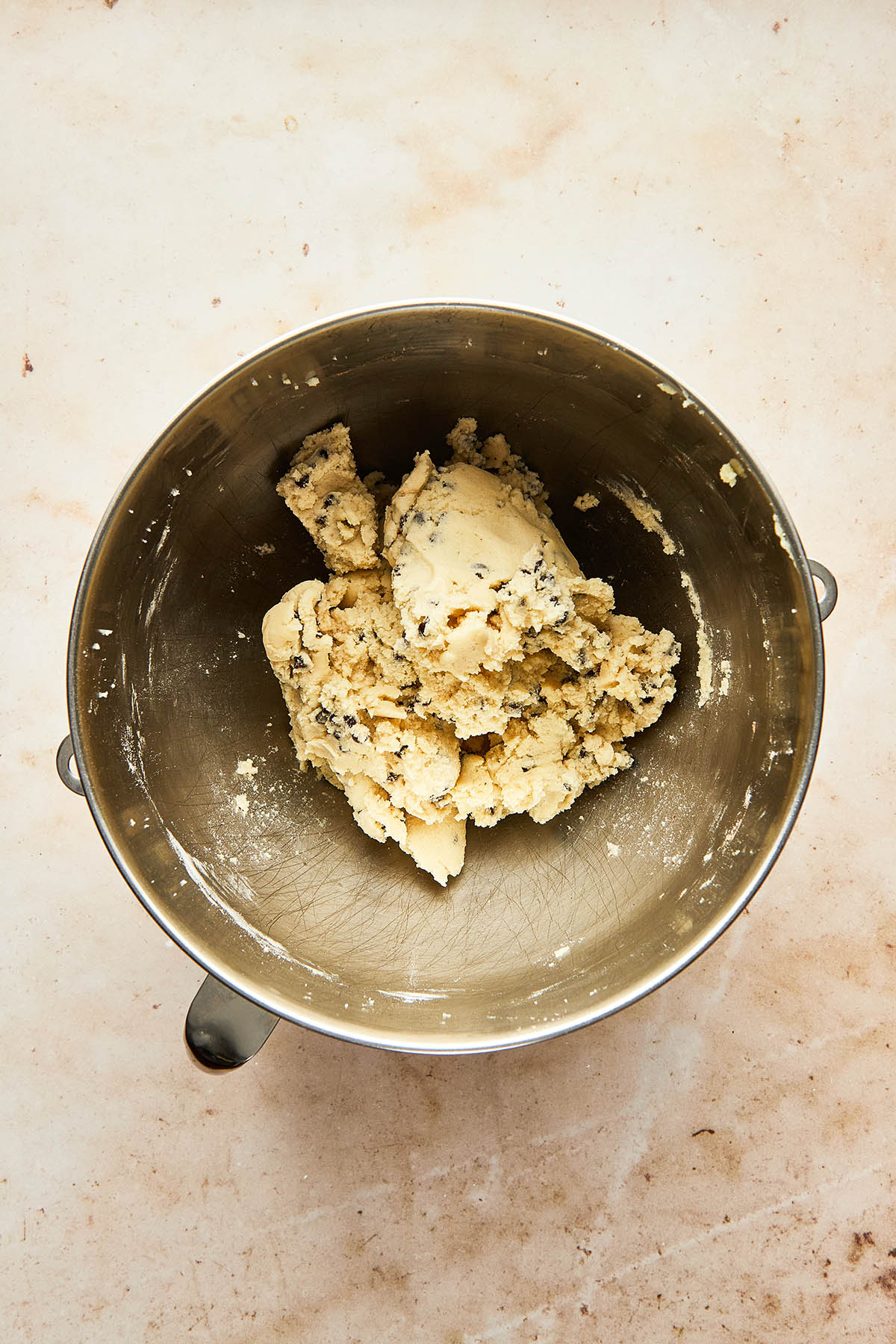 Cookie dough in a metal stand-mixer mixing bowl.