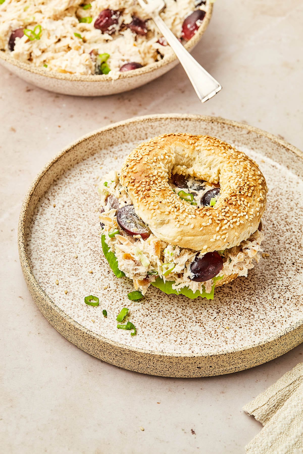 Chicken salad with grapes and almonds on a toasted sesame bagel.
