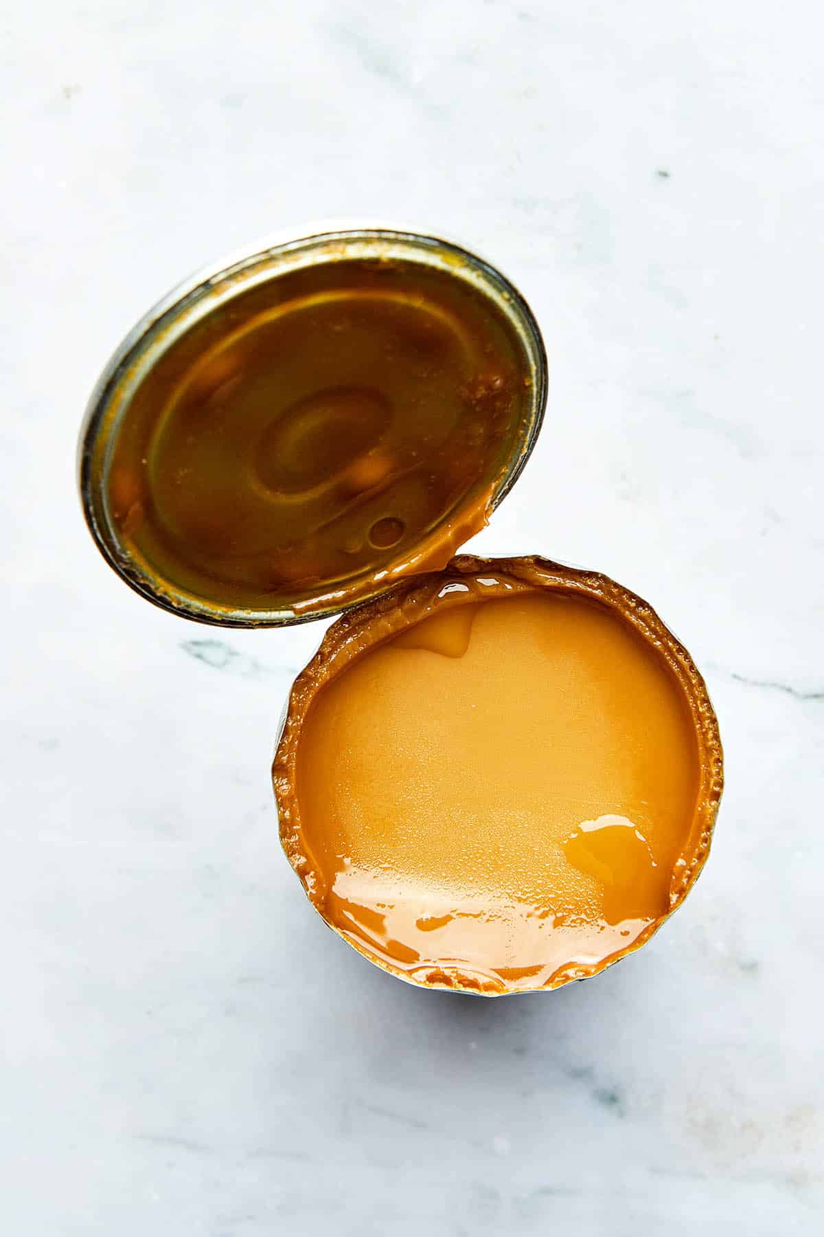 An opened can of Instant Pot dulce de leche with the lid still attached.