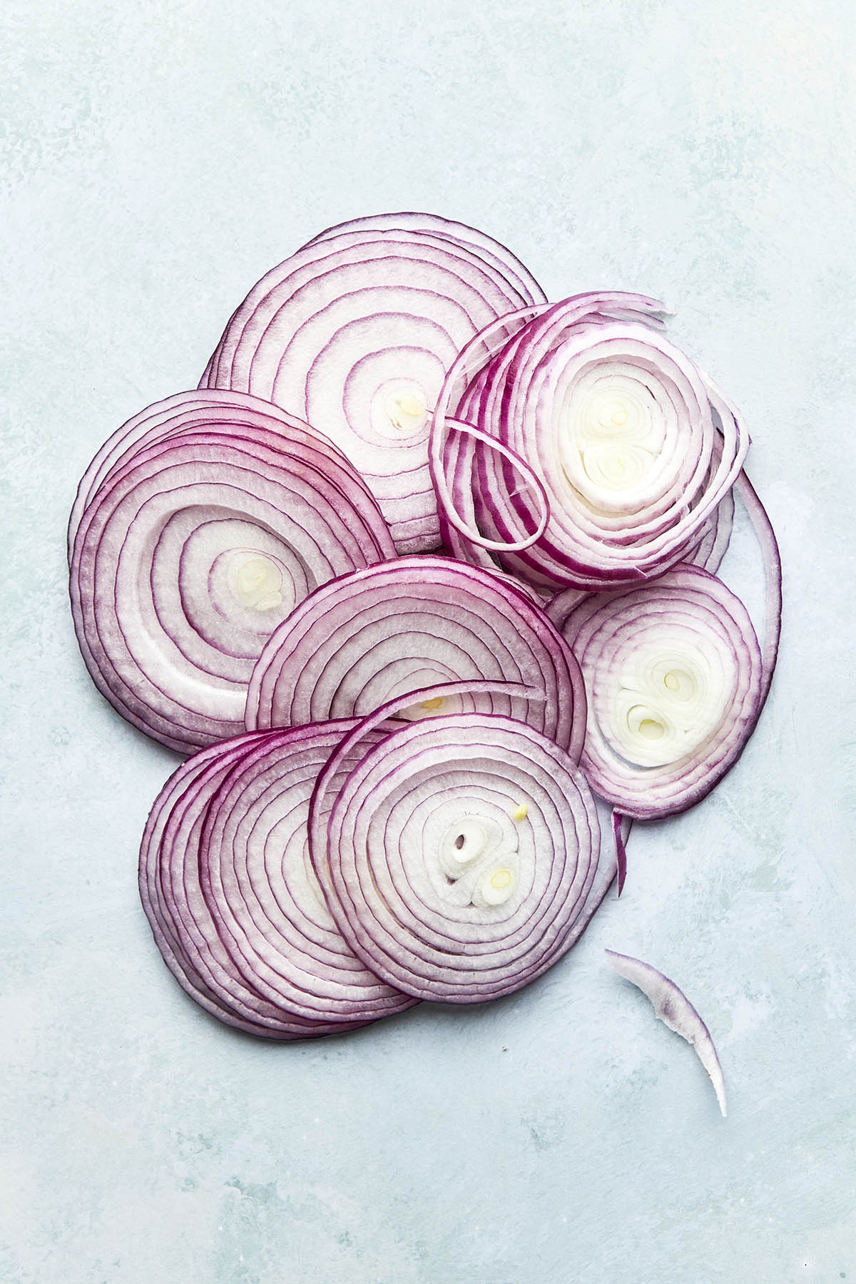 A pile of thinly sliced red onions.