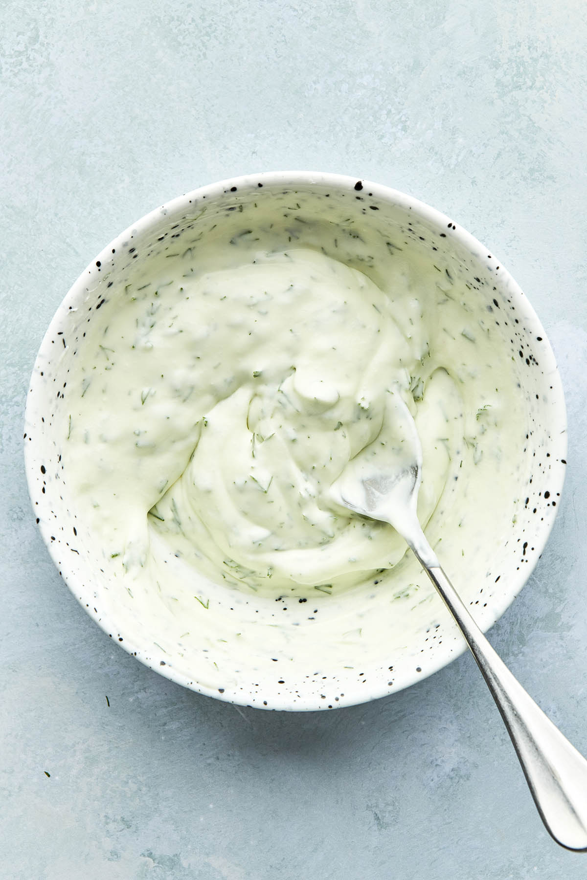 Dill crème fraîche in a bowl with a spoon