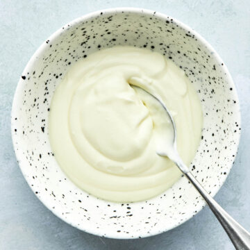 A bowl of crème fraîche with a spoon in the bowl.