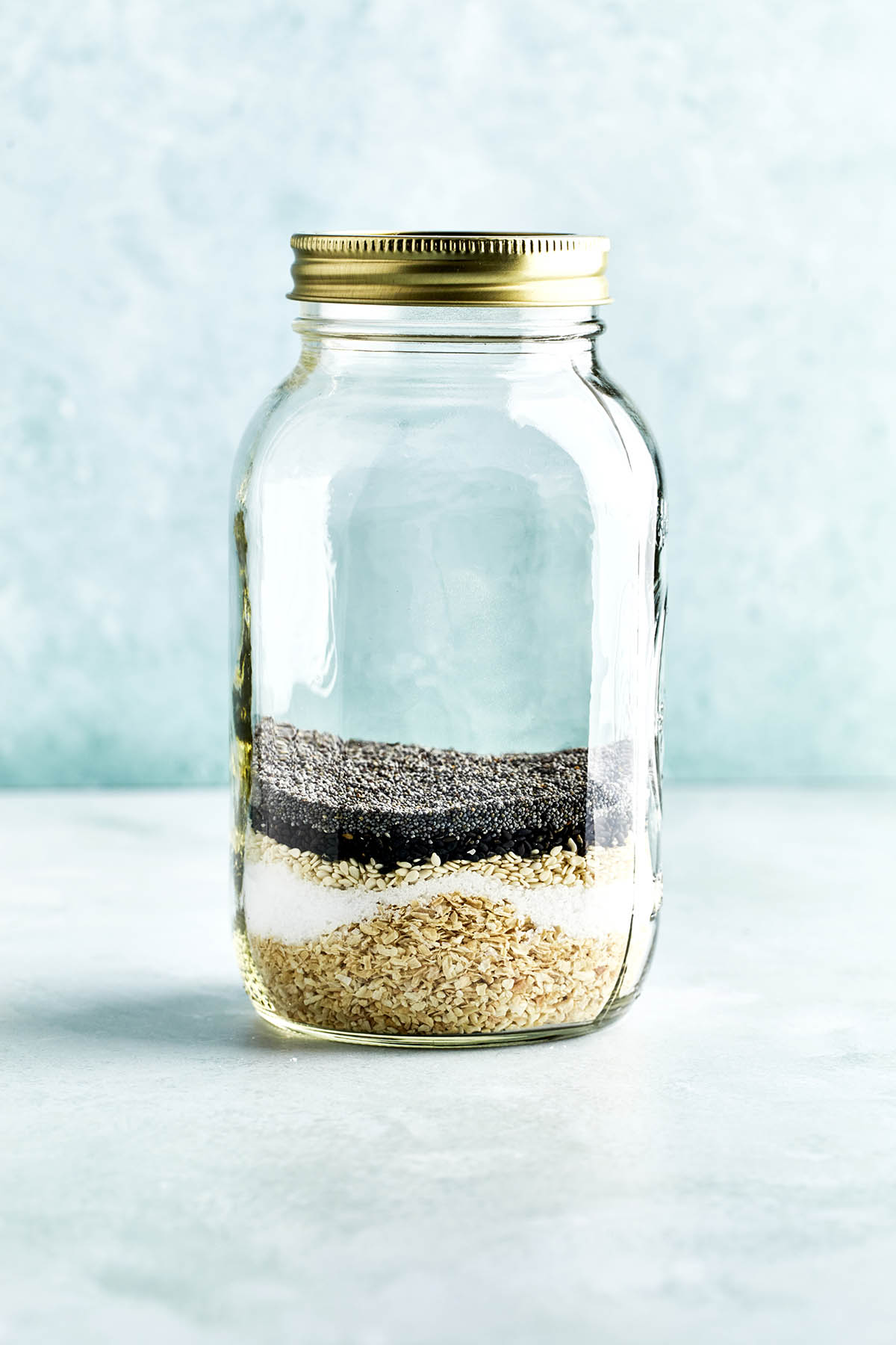 Unmixed everything bagel seasoning in a glass jar.