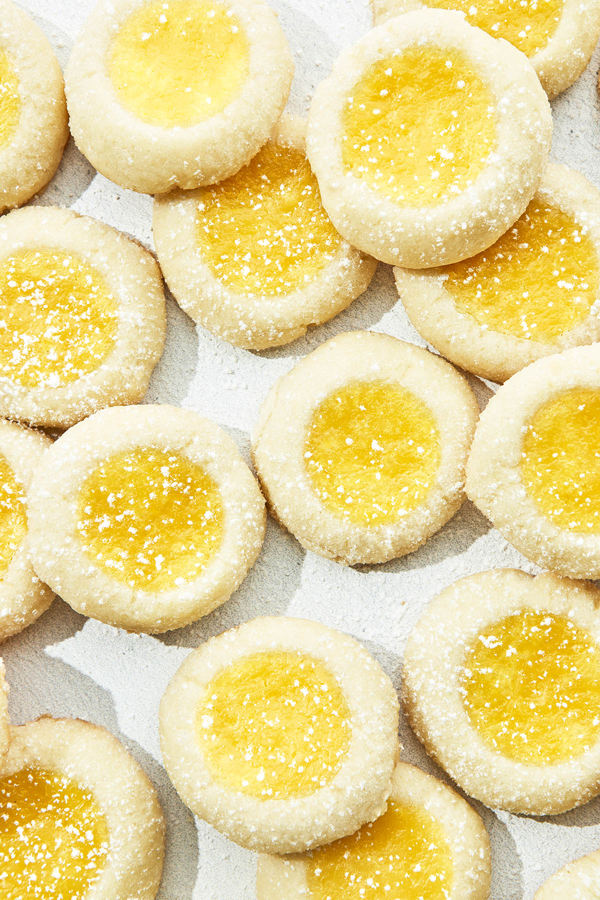 Close up of lemon curd-filled thumbprint cookies, top down in hard light.