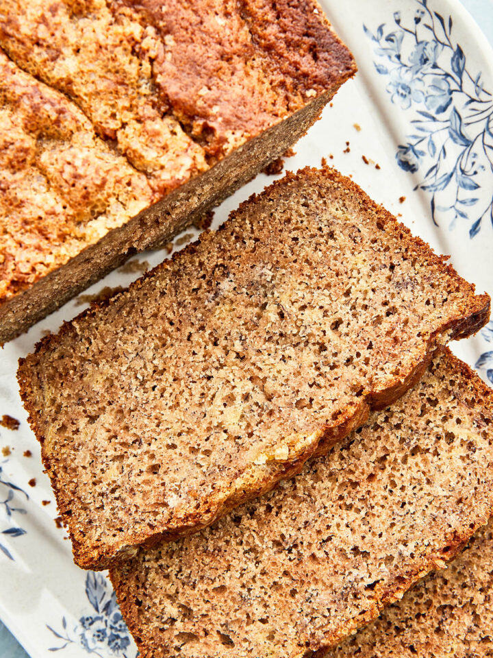 Slices of buckwheat banana bread on a blue and white platter.