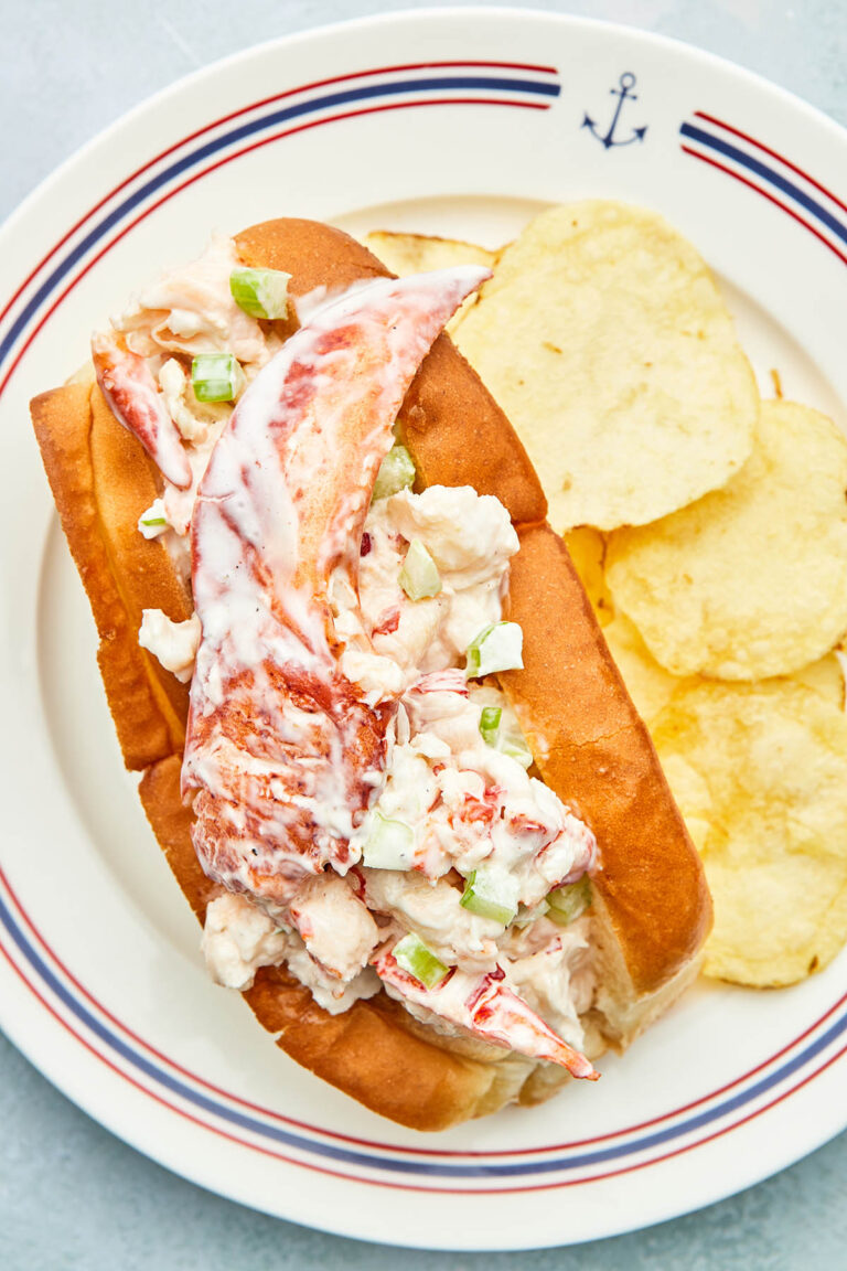 A Nova Scotia lobster roll on a plate with plain potato chips.