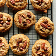 A batch of old-fashioned chocolate chip pecan cookies on a cooling rack.