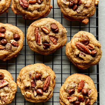 A batch of old-fashioned chocolate chip pecan cookies on a cooling rack.
