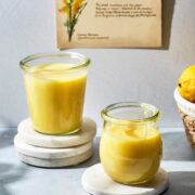 Two jars of microwave lemon curd on a countertop.