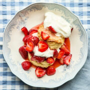 Classic strawberry shortcake in a blue and white bowl on a blue and white gingham tablecloth.