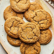 An oval platter of ginger sparklers wih a bowl of coarse sugar and small blue plates nearby.
