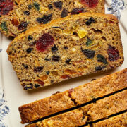 Slices of Christmas fruitcake with rum on a blue and white platter.