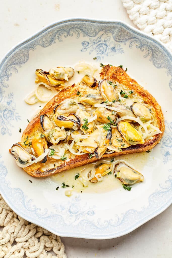 Mussels in lemon cream broth spooned over crisp sourdough toast.