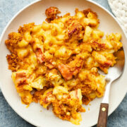 A bowl of lobster mac and cheese on a blue tablecloth.